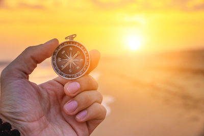 Cropped hand holding navigational compass