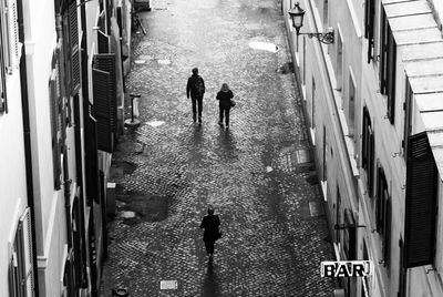 High angle view of silhouette people walking on road in city