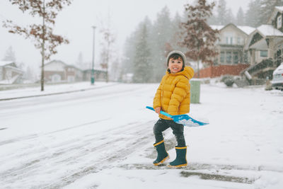 Smiling boy cleaning snow