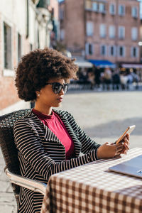 Young business woman checking smart mobile phone