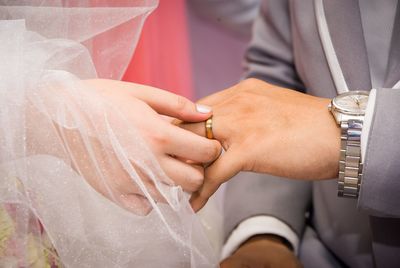 Midsection of couple holding hands