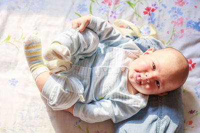 Portrait of baby girl lying on bed