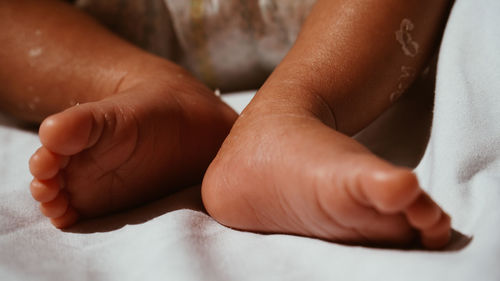 Low section of baby feet on bed