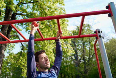 Low angle view of man exercising in playground