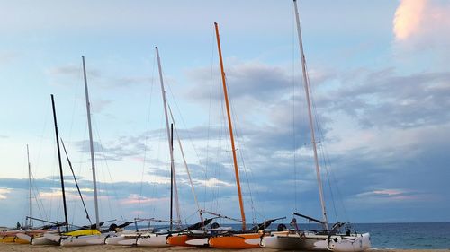 Boats in sea against cloudy sky