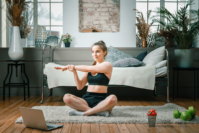 A strong and beautiful sports fitness girl in sportswear meditates in lotus position, resting 