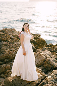 Woman standing on rock by sea