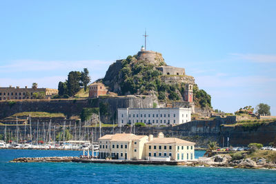 Building by sea against sky in city