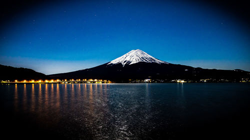 Scenic view of lake against blue sky at night