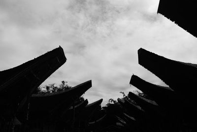 Low angle view of silhouette buildings against sky