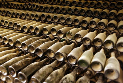 Full frame shot of dust covered wine bottles in warehouse