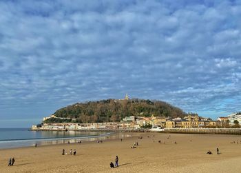 People at beach against sky