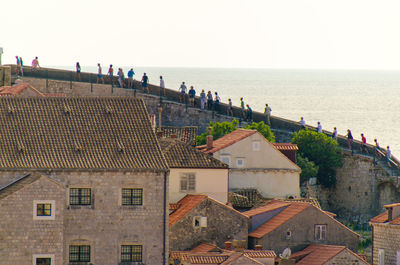 People on steps in town against sea