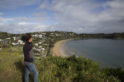 Side view of man standing by plants against sky