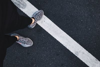 Low section of woman standing on road