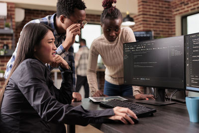 Side view of businesswoman using laptop at office