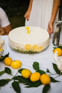 Midsection of woman holding fruits on table