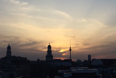 Buildings against cloudy sky at sunset