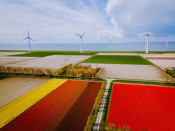 Wind turbines on field against sky