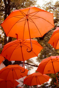 Low angle view of umbrella against orange sky