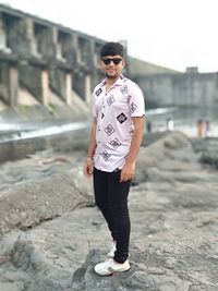 Portrait of young man wearing sunglasses standing outdoors