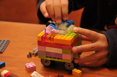 Midsection of woman holding toy blocks on table