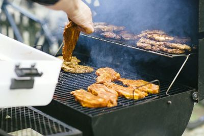 Person grilling steaks on barbecue