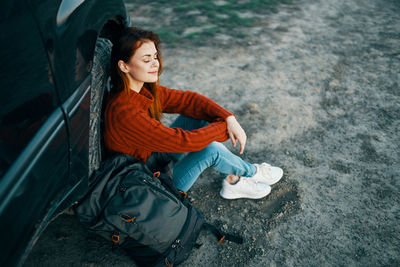 Portrait of smiling young woman sitting outdoors