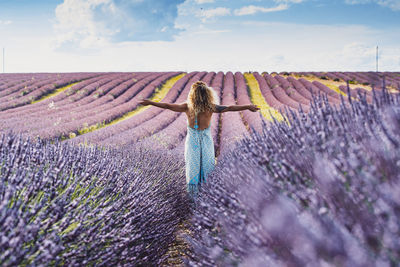 Rear view of woman walking on field