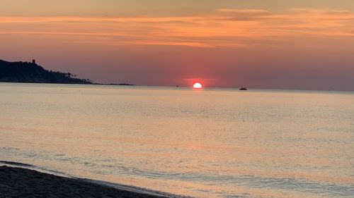 Scenic view of sea against orange sky