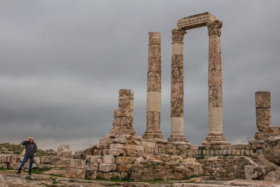 Woman standing at historic building against sky