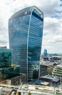 Modern buildings in city against cloudy sky
