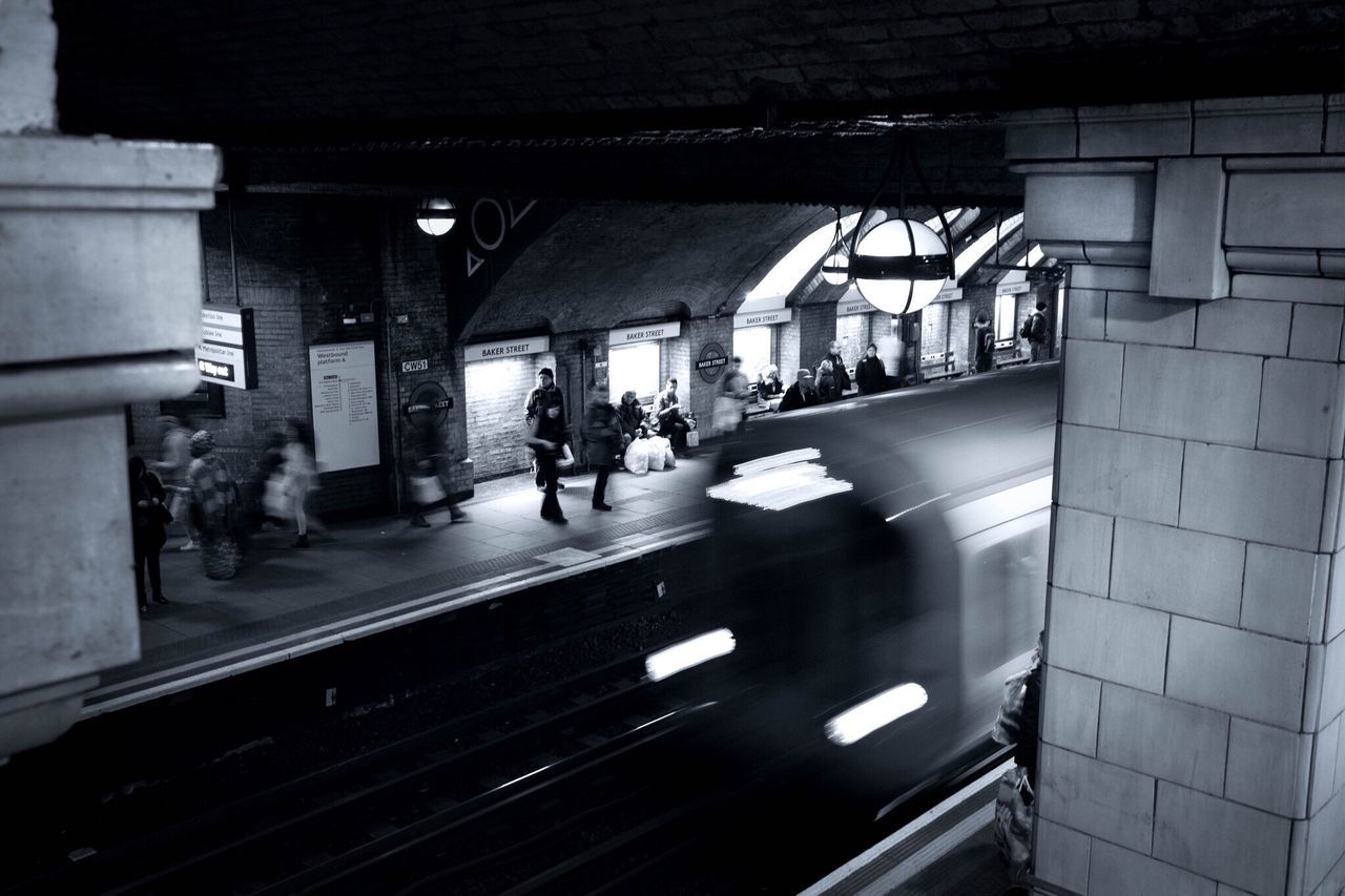 architecture, transportation, built structure, men, walking, indoors, person, city life, city, large group of people, public transportation, lifestyles, high angle view, railroad station, building exterior, illuminated, mode of transport, on the move, street