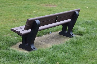 Empty bench on field in park