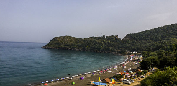 High angle view of people on beach against clear sky