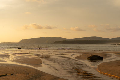 Scenic view of beach against sky during sunset