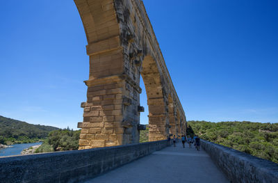 View of tourists against clear blue sky