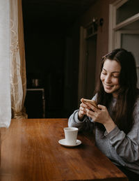 Young woman drinking coffee at home