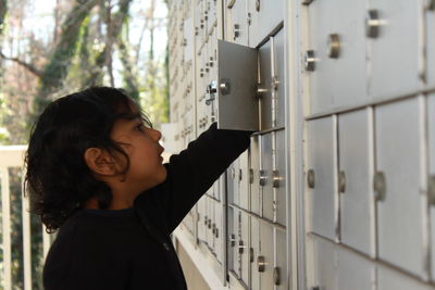 Side view of boy looking in locker