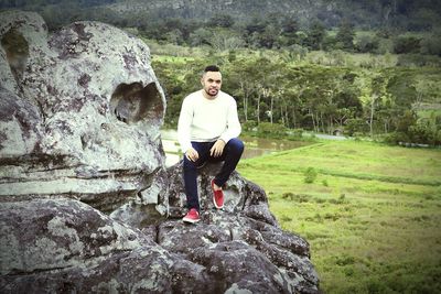 Portrait of man sitting on rock