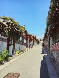 Empty road amidst buildings against clear sky