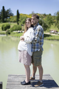 Full length of couple standing on bridge by trees