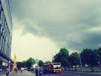 Traffic on road against cloudy sky