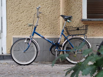 Bicycle leaning against wall in city