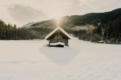 House on snow covered landscape sun winter hut 