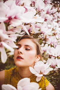 Young woman amidst pink flowers
