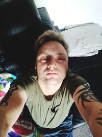 Portrait of young man sitting on bed