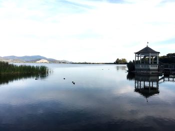 Scenic view of lake by building against sky