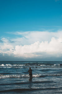 Silhouette person on beach against sky