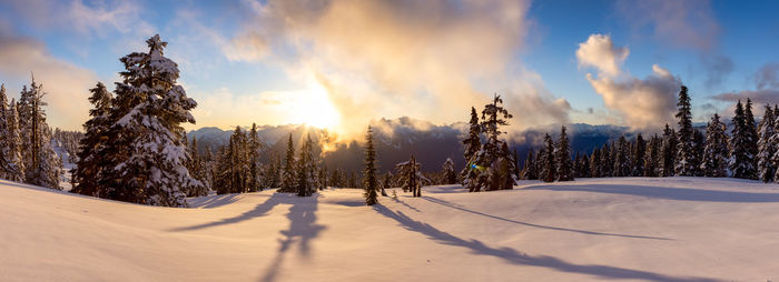 Scenic view of snow covered land against sky during sunset